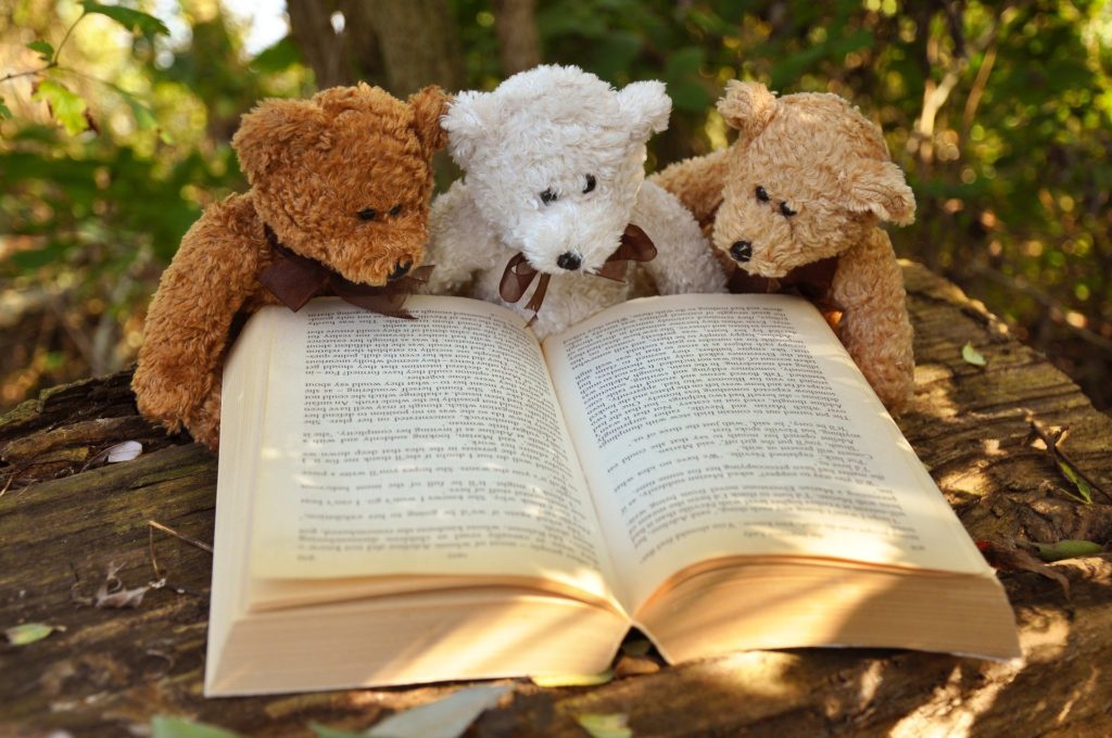 3 oursons en peluche lisent paisiblement un livre avant d'aller se coucher